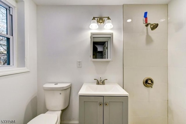 bathroom featuring vanity, tiled shower, and toilet