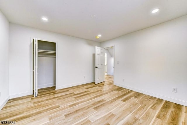 unfurnished bedroom featuring light hardwood / wood-style floors and a closet