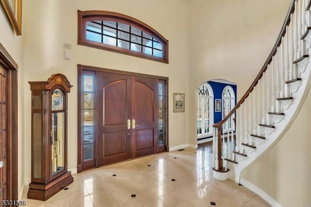 entryway featuring light tile patterned floors and a high ceiling