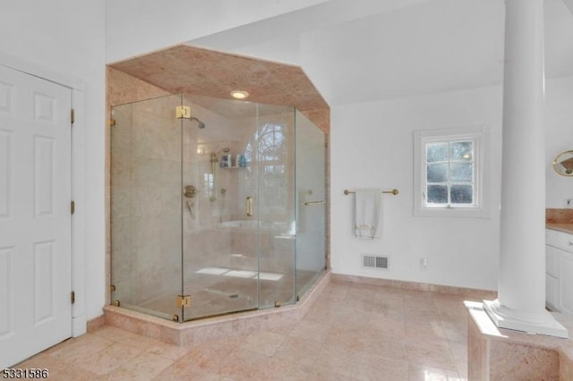 bathroom featuring decorative columns, walk in shower, and vanity