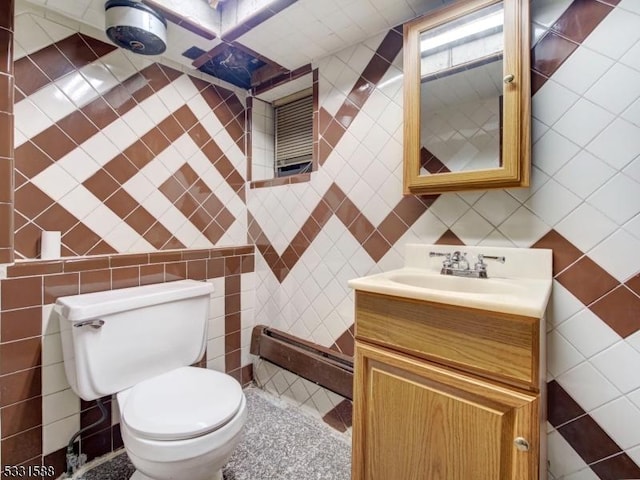 bathroom with vanity, toilet, and tile walls