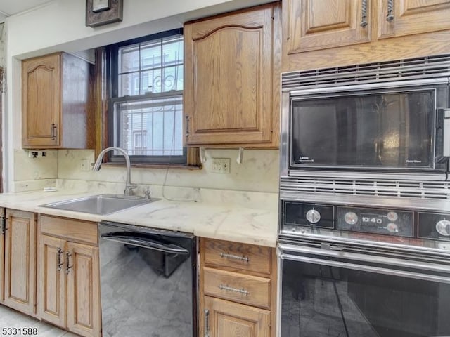 kitchen featuring light stone counters, sink, and black appliances