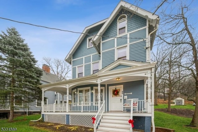 view of front of home with covered porch and a front lawn