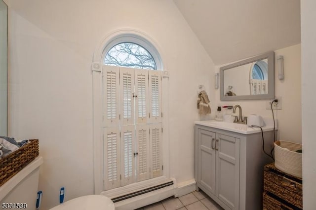 bathroom featuring vanity, vaulted ceiling, tile patterned flooring, toilet, and a baseboard radiator