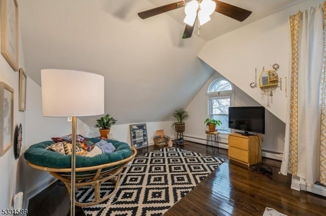 living area with a baseboard heating unit, vaulted ceiling, ceiling fan, and dark wood-type flooring