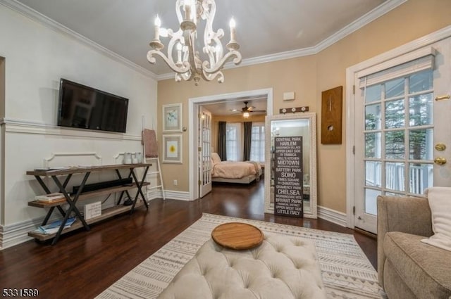 living room with dark hardwood / wood-style floors, ornamental molding, and ceiling fan with notable chandelier