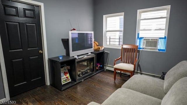 living area with cooling unit, wood finished floors, and a baseboard radiator