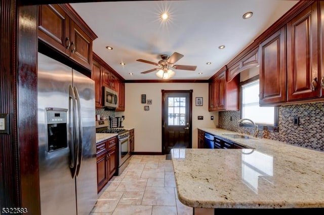 kitchen featuring sink, light stone countertops, ornamental molding, a healthy amount of sunlight, and stainless steel appliances