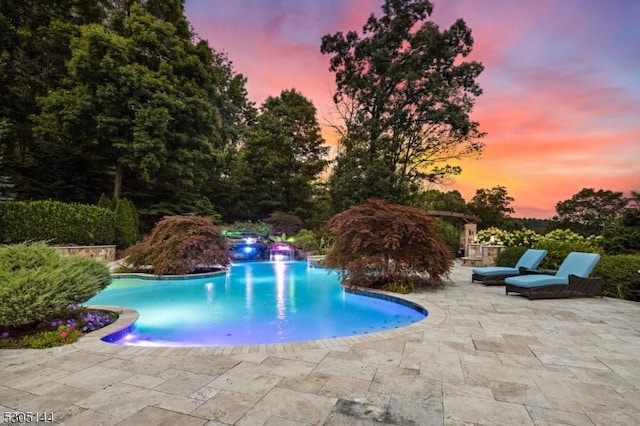 pool at dusk with a patio