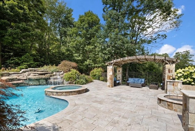 view of swimming pool with pool water feature, a pergola, a patio, and an in ground hot tub