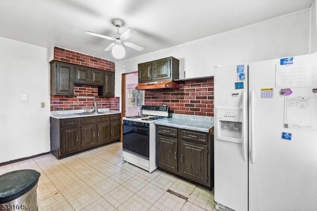 kitchen with dark brown cabinetry, ceiling fan, sink, white appliances, and decorative backsplash