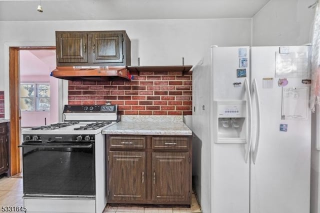 kitchen with tasteful backsplash, dark brown cabinetry, extractor fan, and white appliances