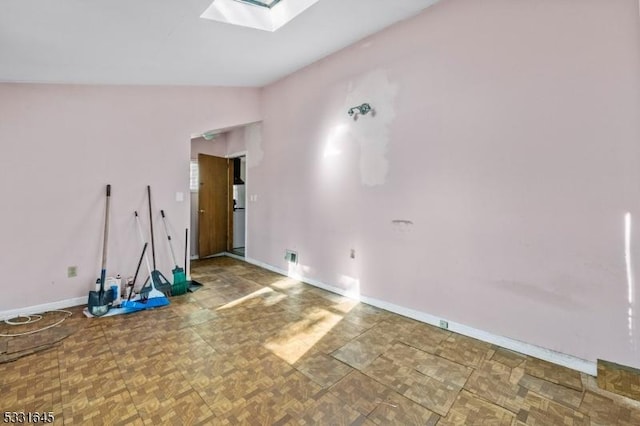 unfurnished room with vaulted ceiling with skylight and parquet floors