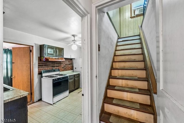 staircase featuring ceiling fan