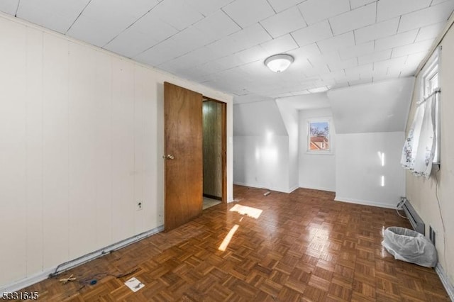 bonus room featuring dark parquet flooring, baseboard heating, and plenty of natural light