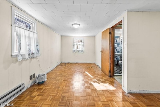 unfurnished room featuring light parquet floors and a baseboard radiator