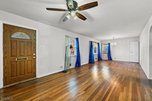 foyer entrance with ceiling fan with notable chandelier and dark wood-type flooring