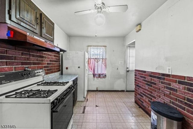 kitchen featuring ceiling fan, dark brown cabinets, and white gas range oven