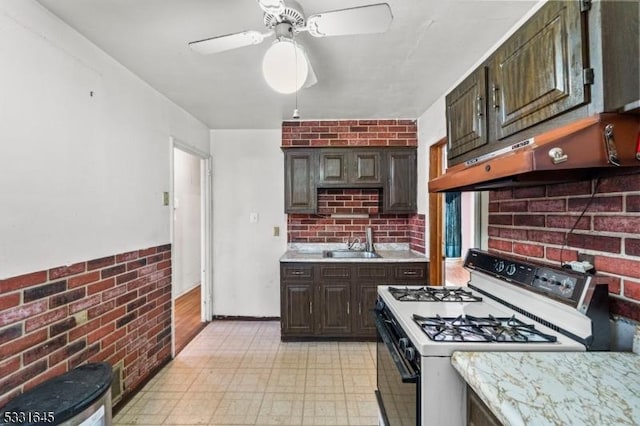 kitchen featuring white gas range, ceiling fan, sink, extractor fan, and dark brown cabinets