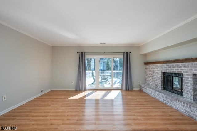 unfurnished living room with ornamental molding, light wood-type flooring, and a brick fireplace