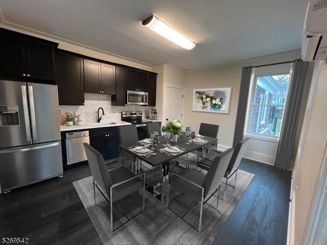 kitchen with decorative backsplash, ornamental molding, stainless steel appliances, a wall unit AC, and dark wood-type flooring