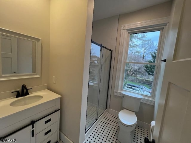 bathroom featuring vanity, toilet, and a shower with shower door