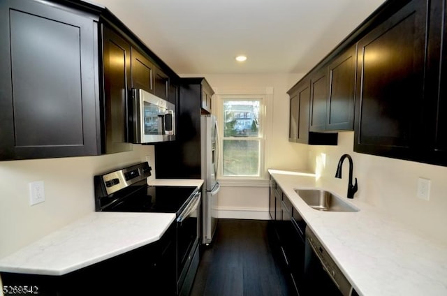 kitchen with sink, dark brown cabinetry, stainless steel appliances, and dark wood-type flooring