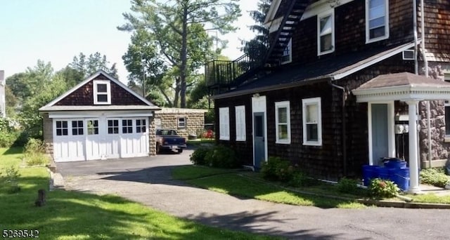 view of front of house with a garage and an outbuilding