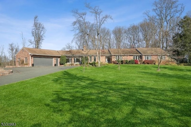 ranch-style home with a garage and a front lawn