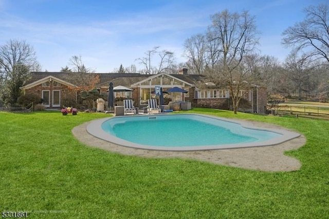 view of pool featuring a lawn and a patio area