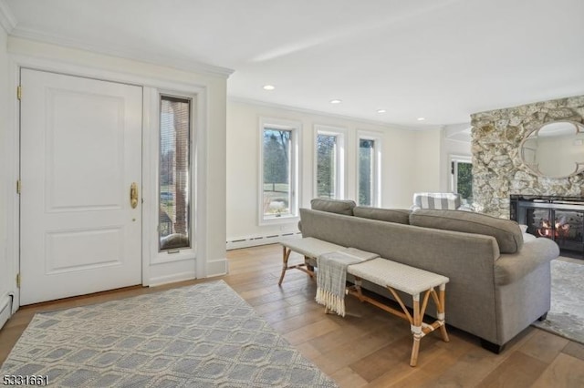 living room featuring hardwood / wood-style floors, a baseboard radiator, and crown molding