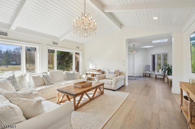 living room with vaulted ceiling with beams, an inviting chandelier, and light hardwood / wood-style flooring