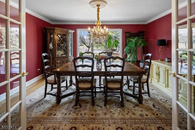 dining area with french doors, a notable chandelier, hardwood / wood-style floors, and ornamental molding