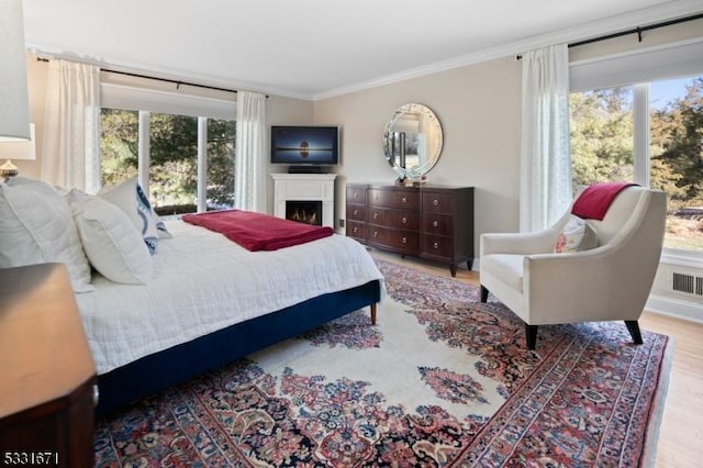 bedroom with ornamental molding and light hardwood / wood-style flooring