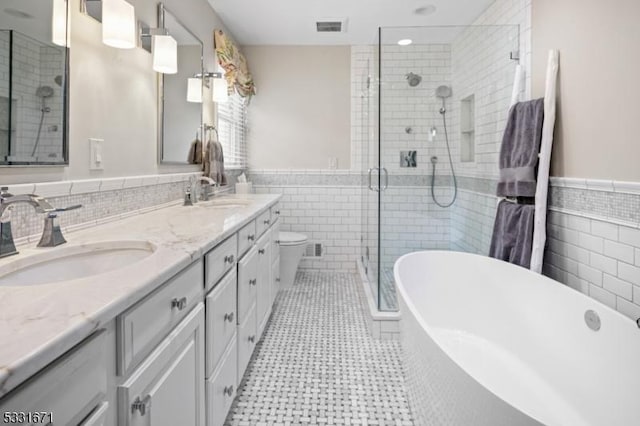 full bathroom with toilet, vanity, tile walls, and plus walk in shower