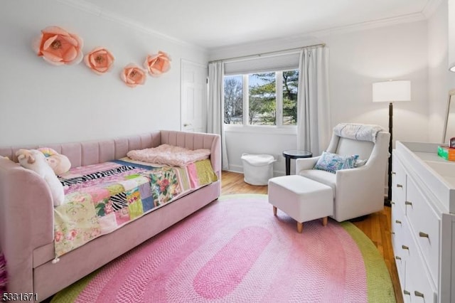 bedroom with light hardwood / wood-style floors and crown molding