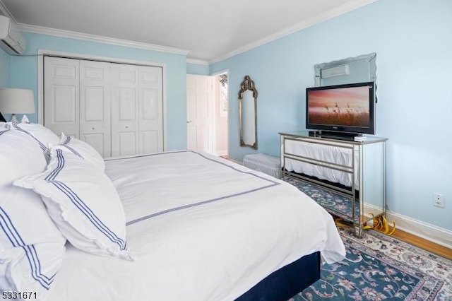 bedroom featuring hardwood / wood-style flooring, a wall mounted AC, ornamental molding, and a closet