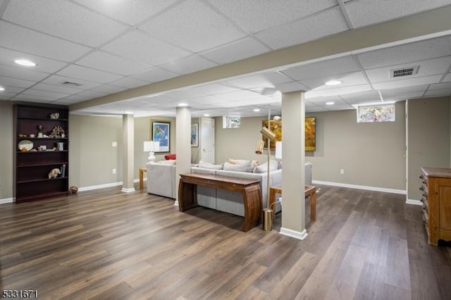 interior space with a paneled ceiling and dark hardwood / wood-style floors