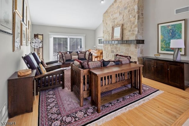 living room featuring light wood-type flooring and vaulted ceiling