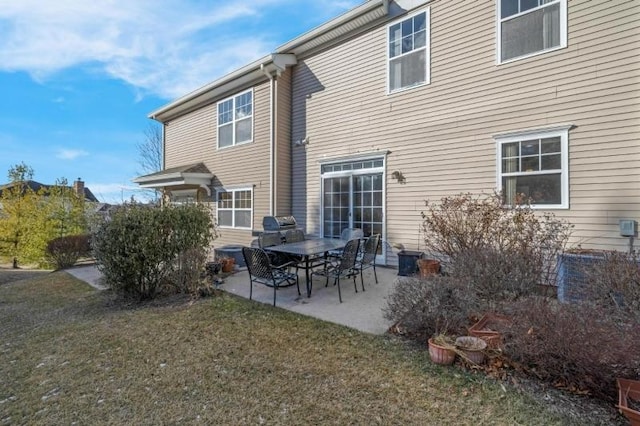 back of property with a yard and a patio