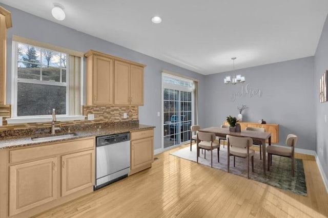 kitchen featuring sink, hanging light fixtures, stainless steel dishwasher, a notable chandelier, and backsplash