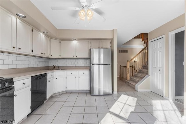 kitchen featuring white cabinetry, dishwasher, stainless steel fridge, and tasteful backsplash