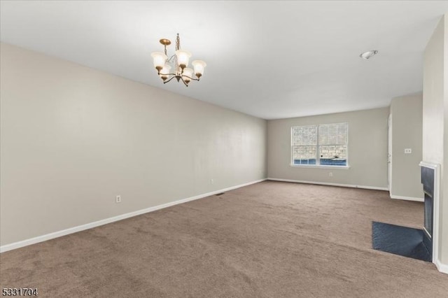 unfurnished living room featuring carpet floors and an inviting chandelier