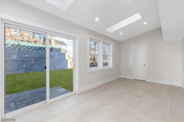 spare room with vaulted ceiling with skylight