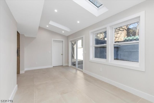 unfurnished room with lofted ceiling with skylight and light tile patterned floors