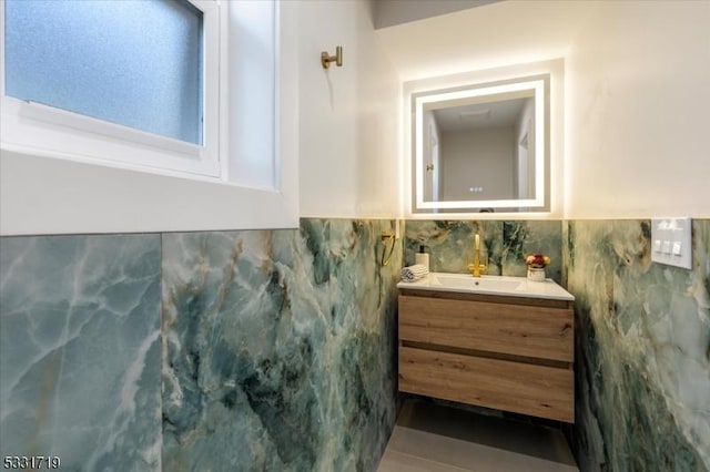 bathroom featuring vanity and tile walls