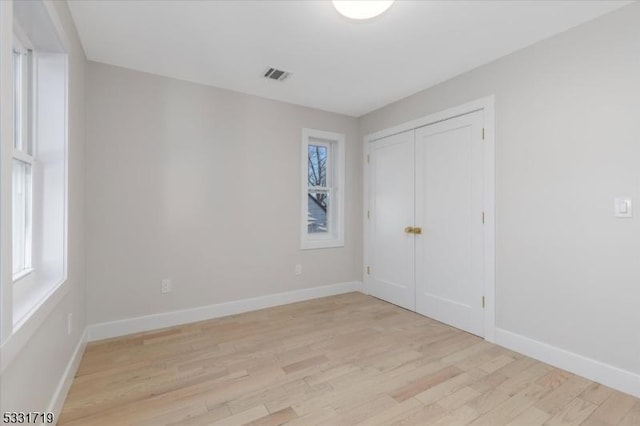 unfurnished bedroom with light hardwood / wood-style floors and a closet