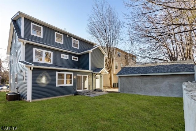 back of house featuring a yard and central AC