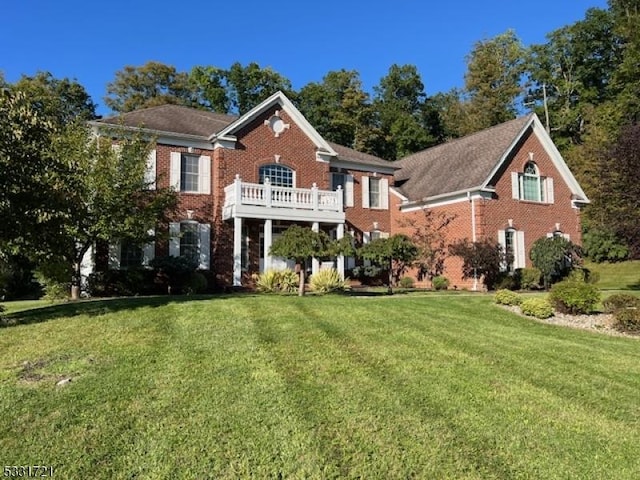 view of front of property with a balcony and a front lawn