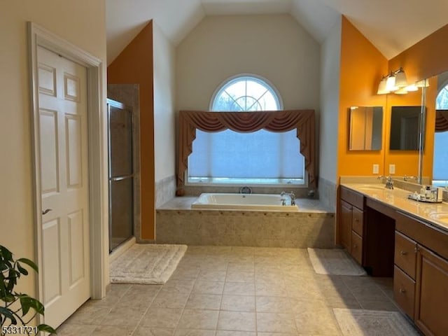 bathroom with tile patterned floors, vanity, independent shower and bath, and vaulted ceiling